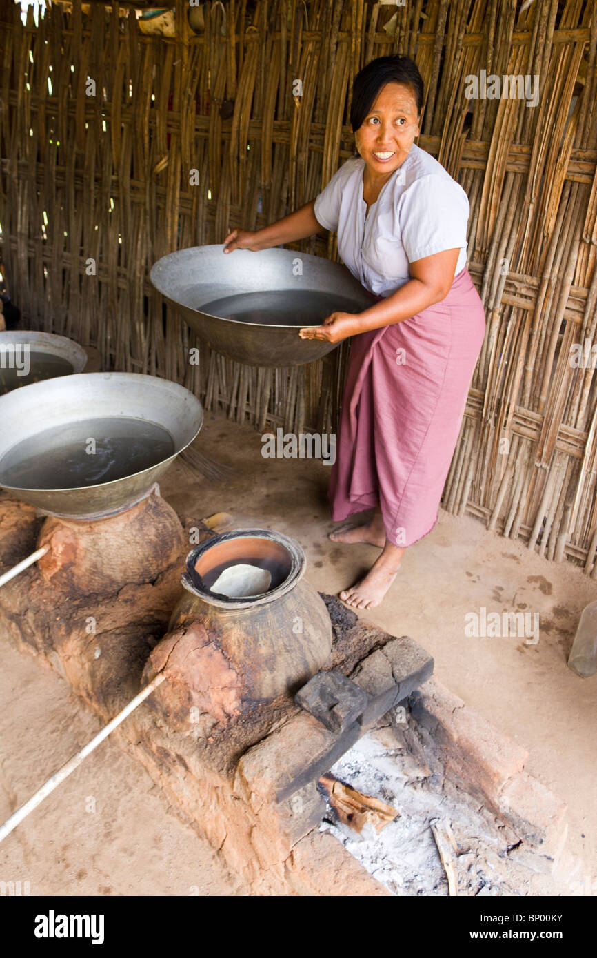 Donna alla distilleria rendendo il vino di riso, vicino a Bagan, Myanmar Foto Stock