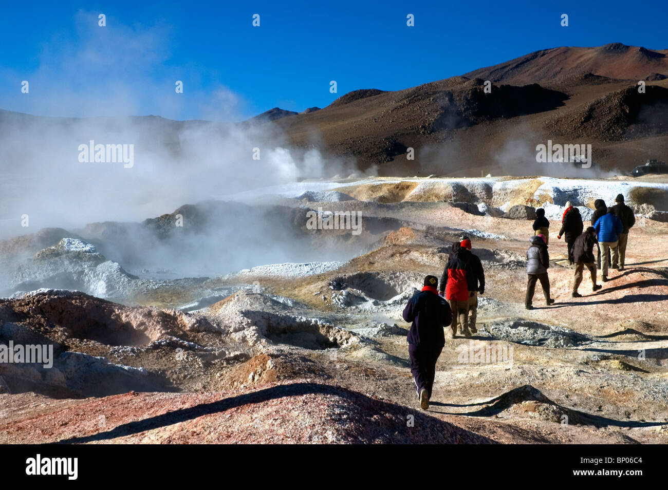 I turisti in mezzo alle piscine di fango bollente al Sol de Manana Geyser Basin in Bolivia. Foto Stock