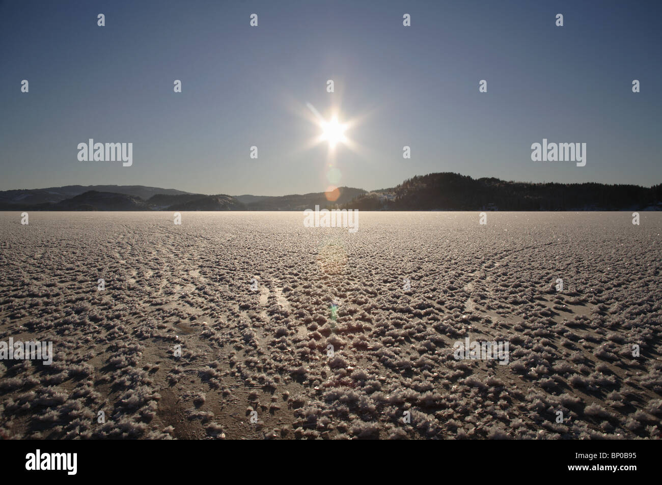 Lago ghiacciato, sun bassa sull'orizzonte Foto Stock