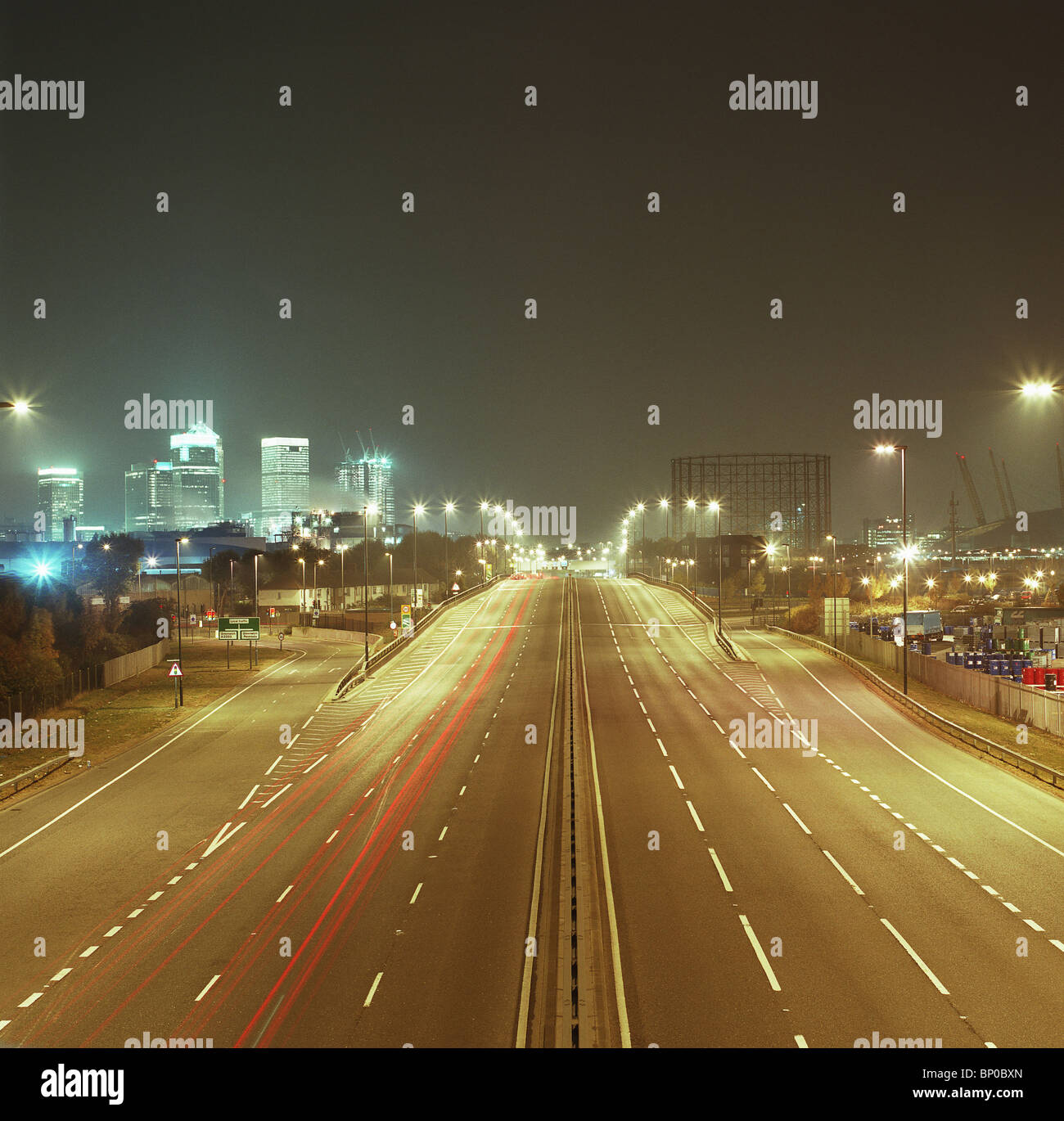 Strada che conduce verso il paesaggio urbano di notte Foto Stock