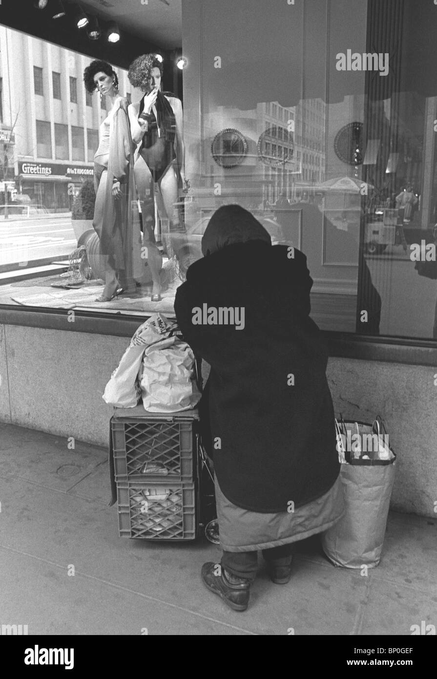 Vecchia donna senzatetto con averi sulla Fifth Avenue di fronte Bergdorf Goodman Dept. Store. in New York City. Foto Stock
