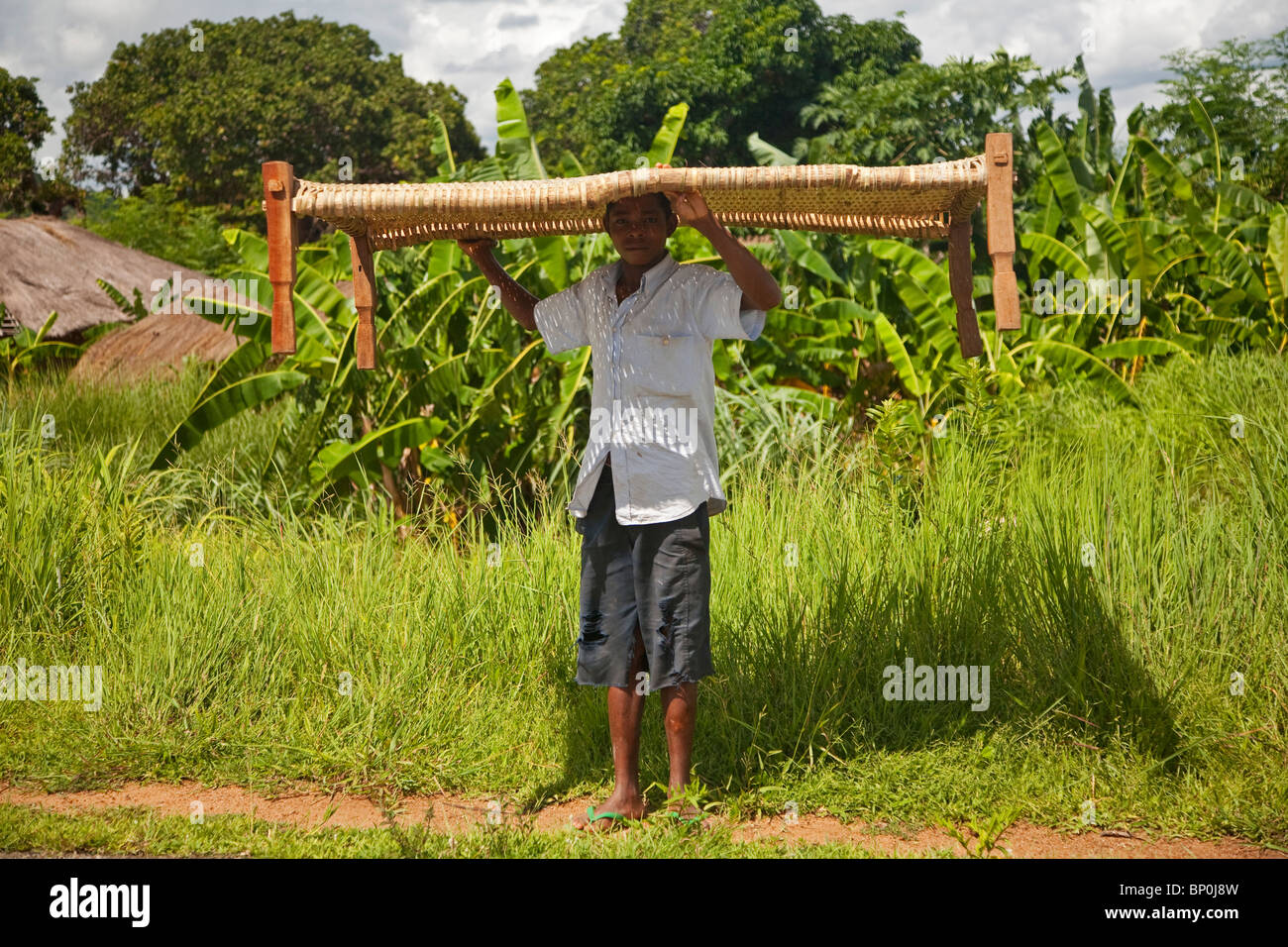 Mozambico. Un ragazzo cammina lungo la strada che porta al suo letto. Foto Stock