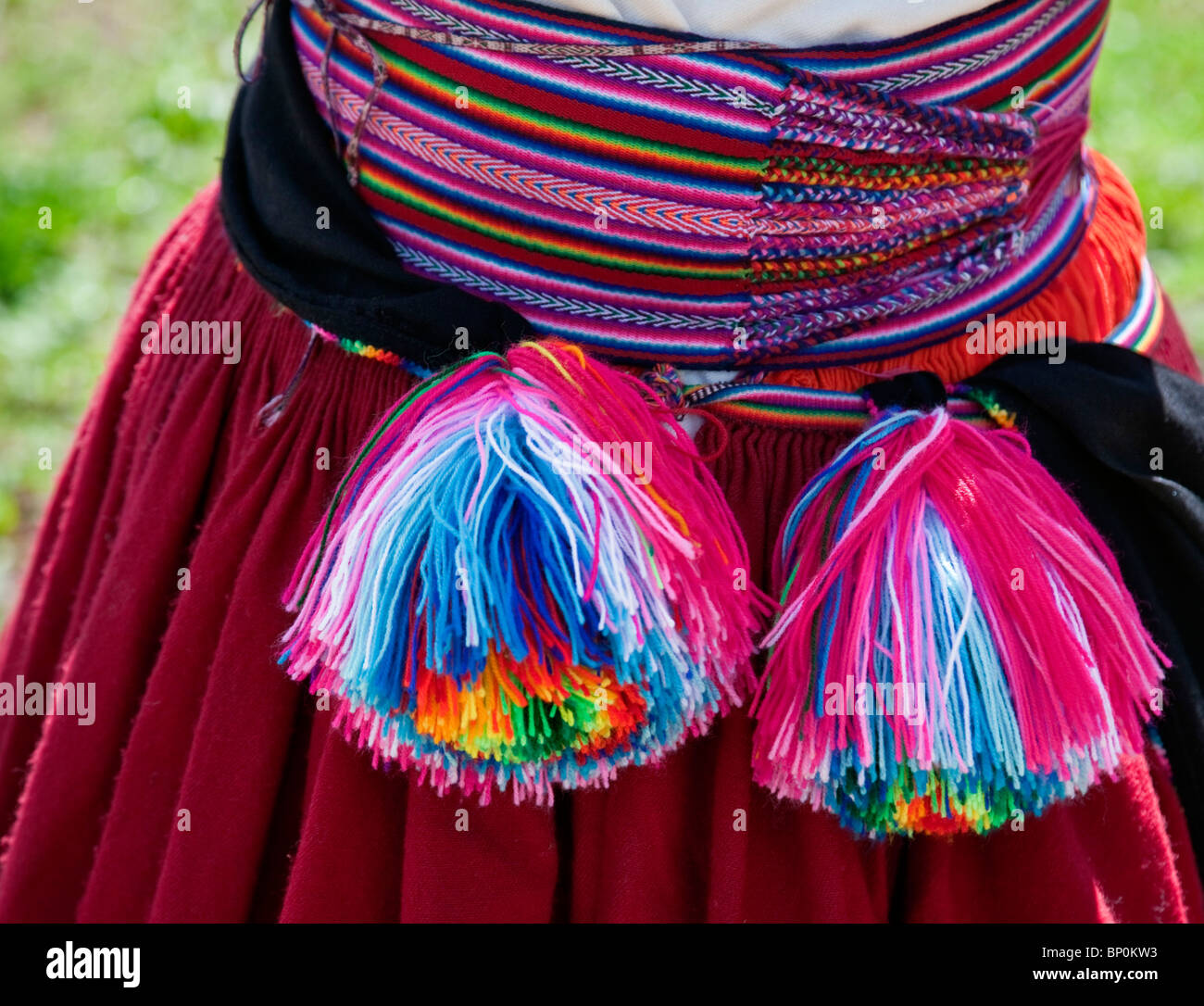 Il Perù, splendidamente cinghia intessuta di una Quechua-parlando la donna a Taquile isola da cui appendere lanosi pompon. Foto Stock