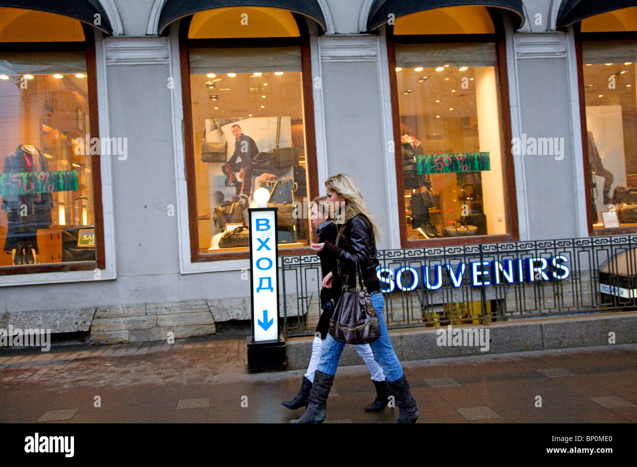 La Russia, San Pietroburgo; due ragazze russe a piedi lungo Nevski Prospekt davanti ai negozi Foto Stock