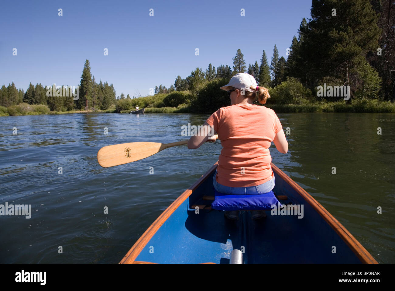 Una donna paddling una canoa sul fiume Deschutes, Oregon Foto Stock