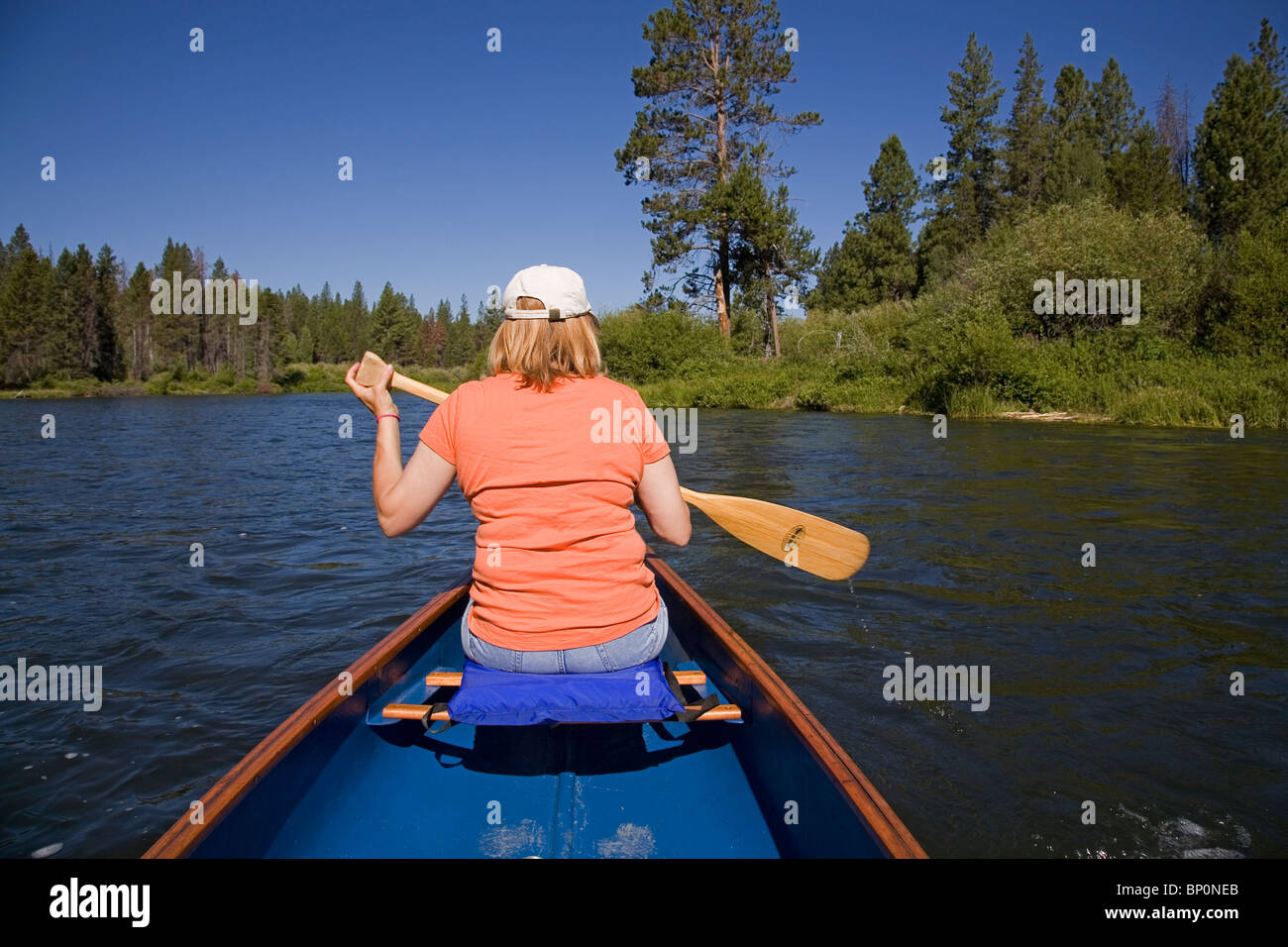 Una donna paddling una canoa sul fiume Deschutes, Oregon Foto Stock