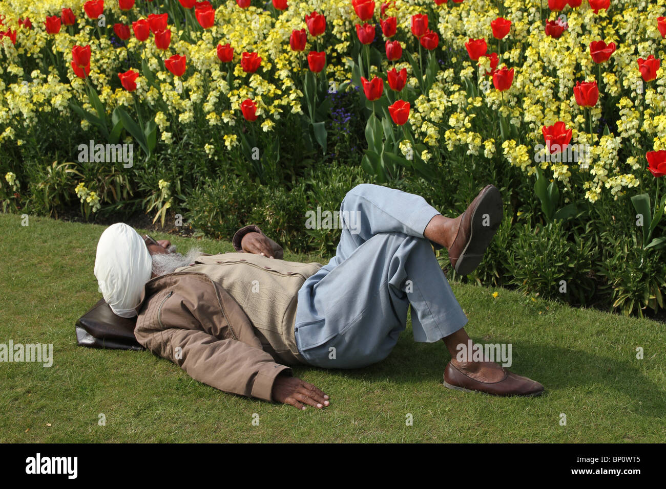 Mettere i piedi stanchi durante una visita a Buckingham Palace in una calda giornata di primavera Foto Stock