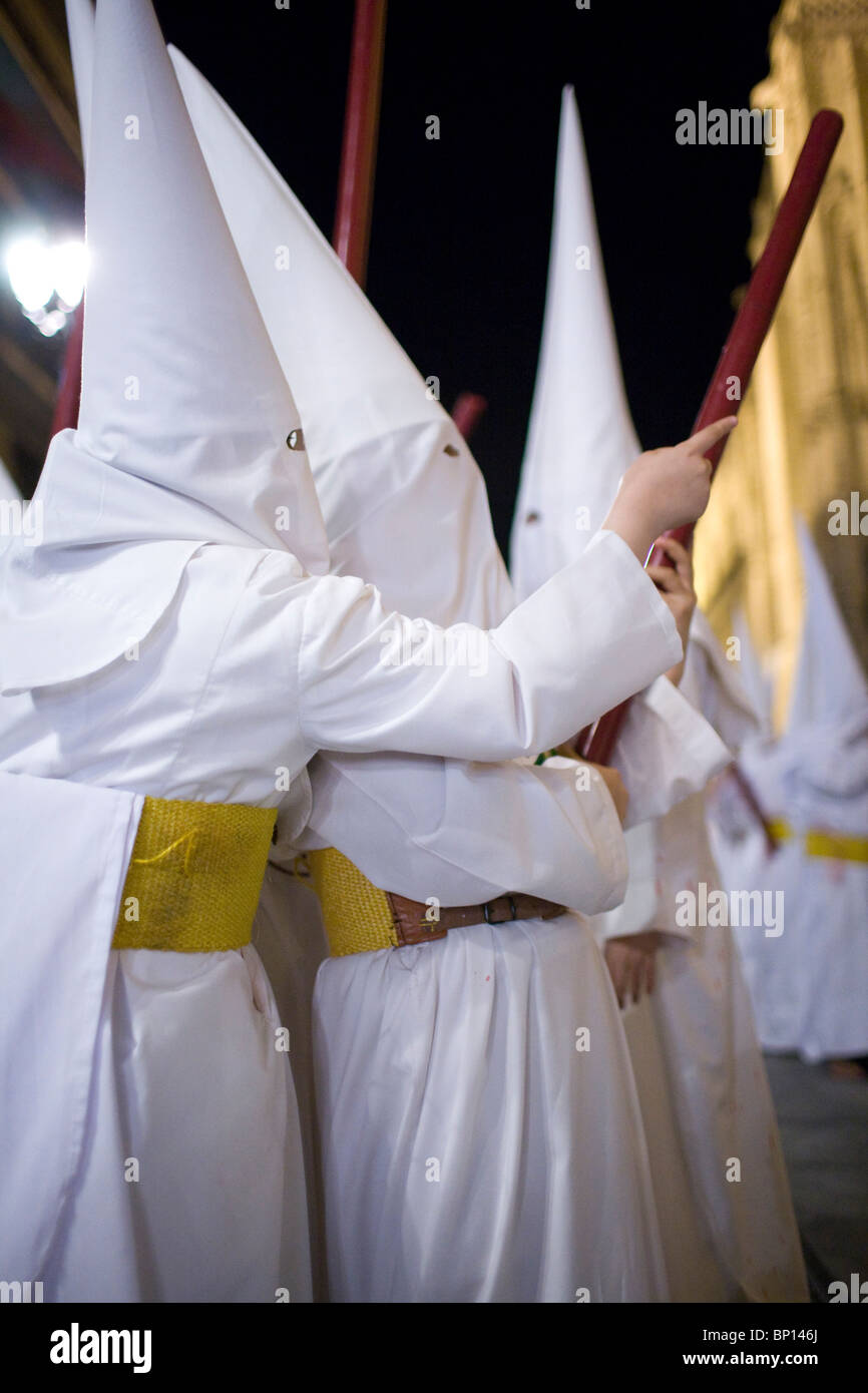 I credenti in vesti bianche in la processione di Pasqua, Siviglia, Spagna Foto Stock