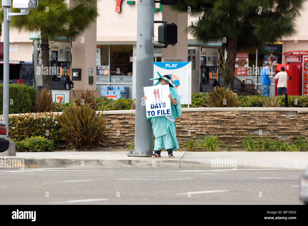 Preparazione fiscale: l uomo nella Statua della Libertà del Costume imposta pubblicizza i servizi di preparazione. Foto Stock