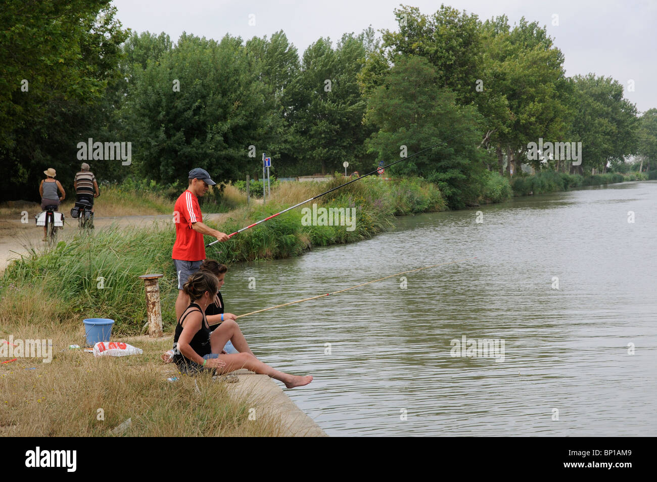 I ragazzi di pesca sul Canal du Midi a Portiranges vicino a Beziers Sud della Francia Foto Stock