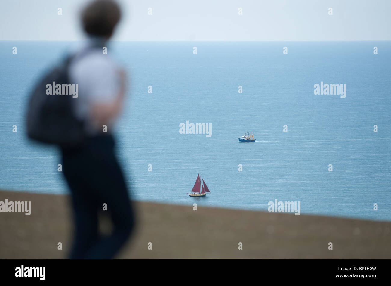 Walker a Beachy Head con barche distanti nel canale in inglese Foto Stock