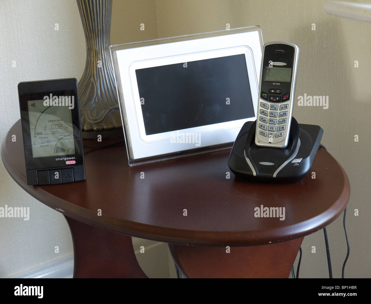 Home energia monitor sul tavolo con cornice fotografica digitale e telefono, Inghilterra, Regno Unito. Foto Stock