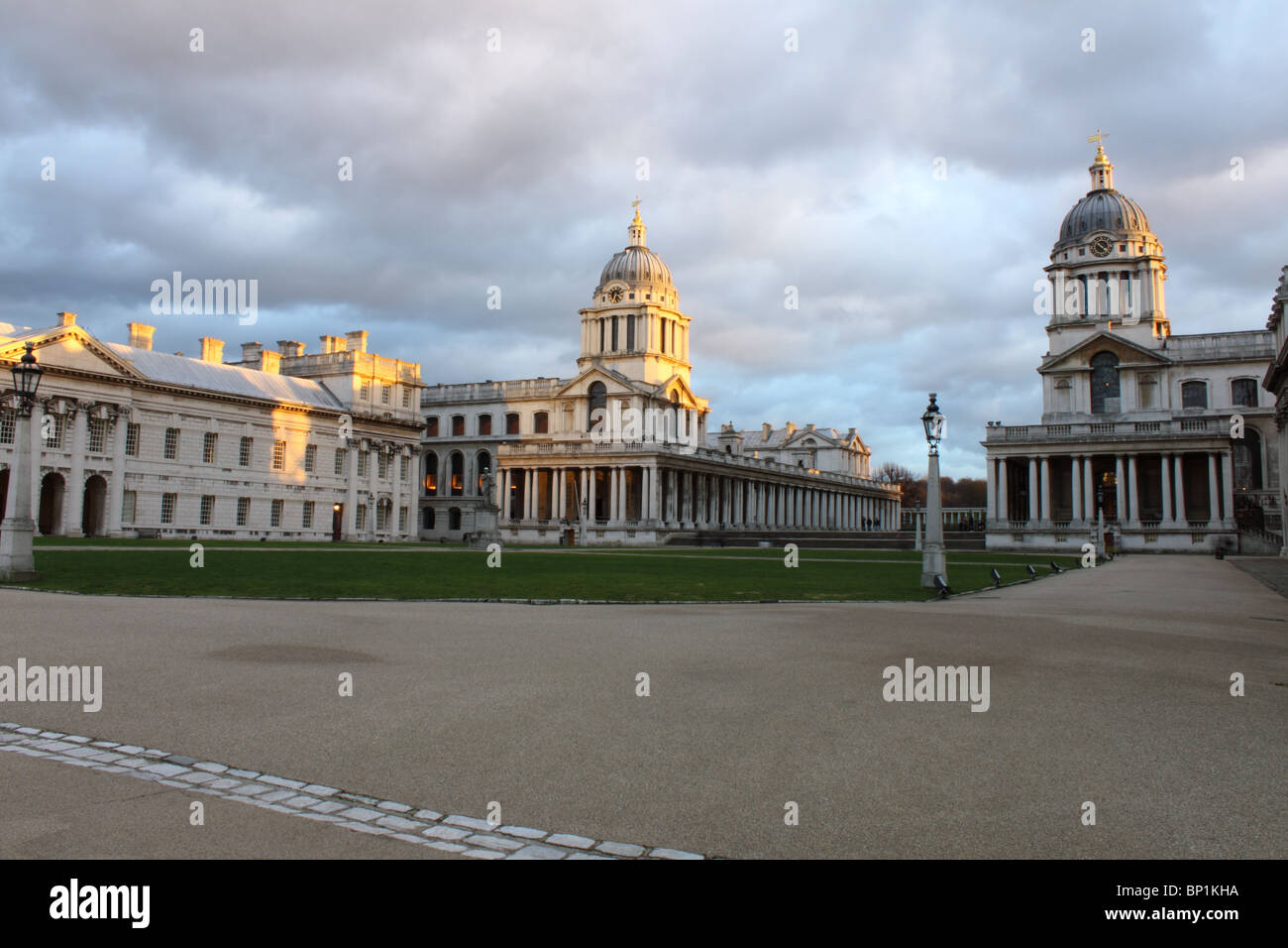 Cortile del Royal Naval College di Greenwich, Londra, Inghilterra, Regno Unito con la luce della sera sulle torri e grigio cielo pezzata Foto Stock