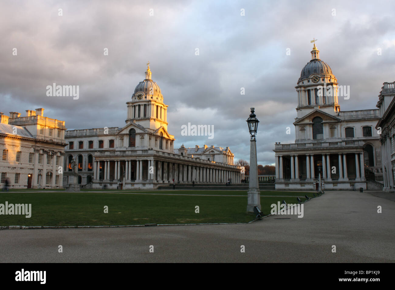 Cortile del Royal Naval College di Greenwich, Londra, Inghilterra, Regno Unito con la luce della sera sulle torri e grigio cielo pezzata Foto Stock