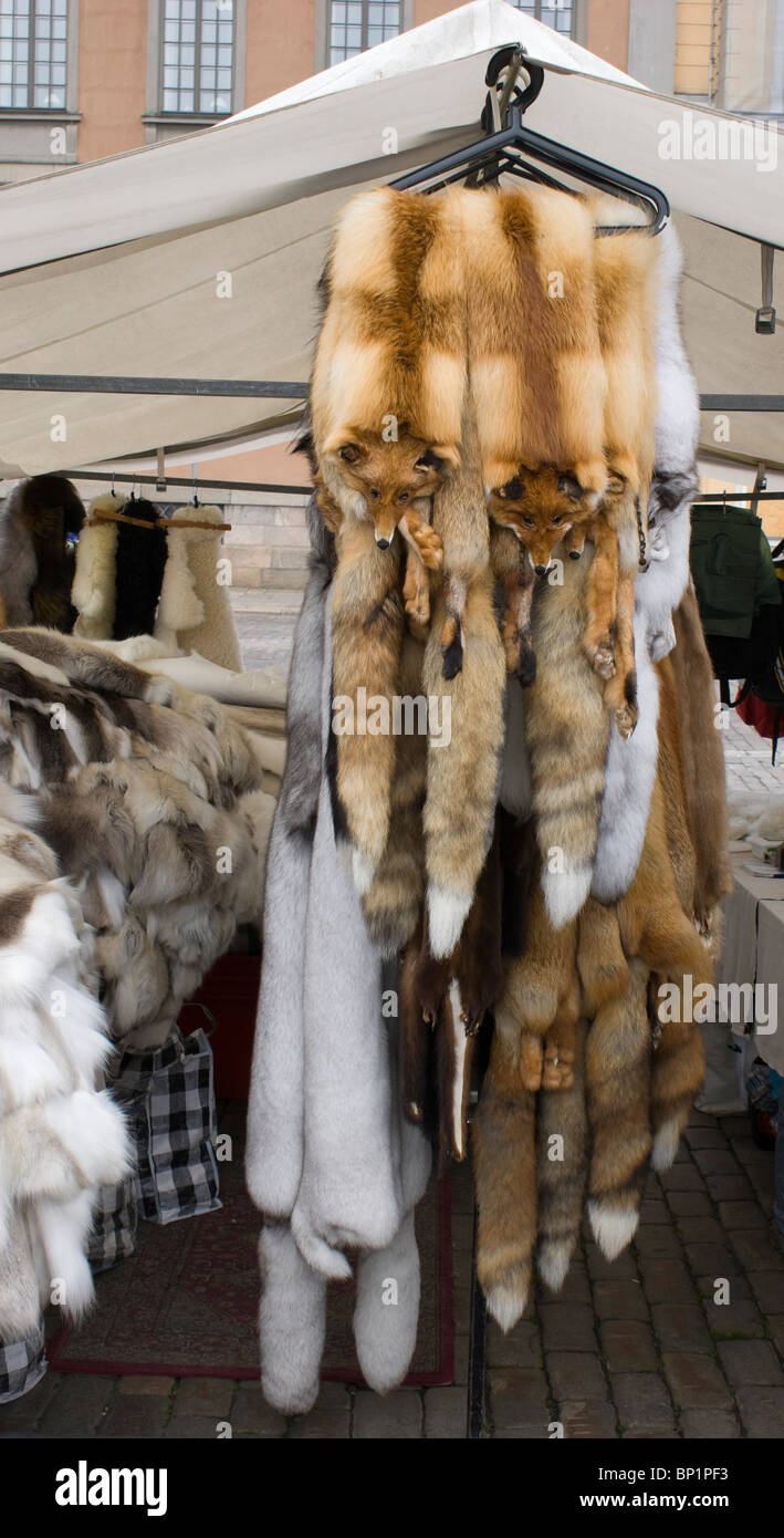 Una pelliccia in stallo la Kauppatori quayside mercato di Helsinki. Una cremagliera di fox pelliccia Pellicce è prominente nella parte anteriore. Foto Stock