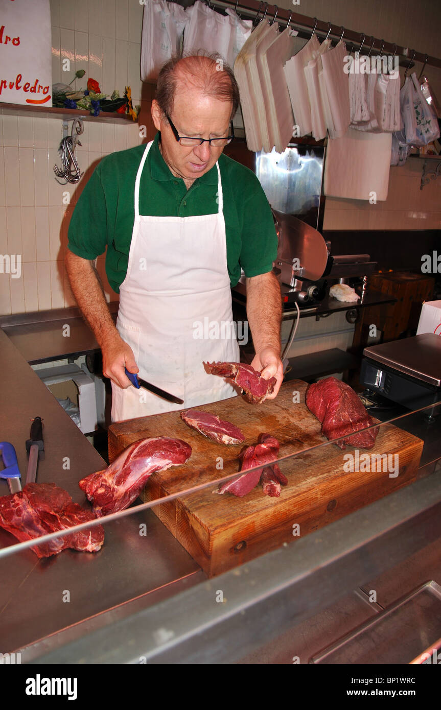 Butcher il taglio di carne in una macelleria a Venezia Italia Foto Stock