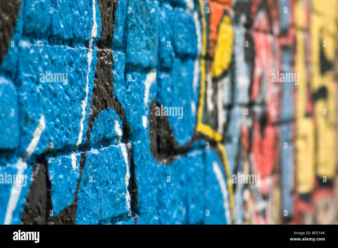 Pietra Grezza di una superficie di una parete ricoperta con colorati graffiti. Strada urbana art. Foto Stock
