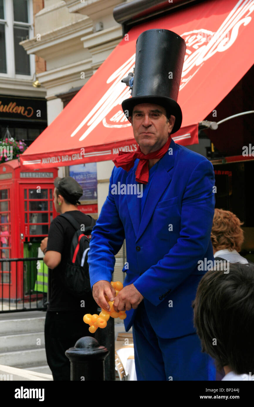 Visita al giardino di Covent di mercato di Apple per vedere gli spettacoli degli artisti di strada - The Mad Hatter e il suo palloncino animale. Foto Stock