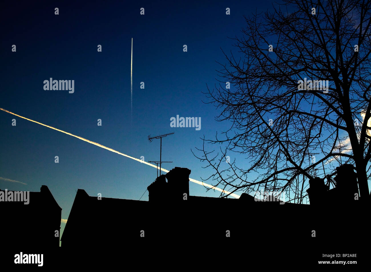 Piano sentieri di vapore nella tarda sera Cielo, impostato su stagliano case vittoriane nel nord di Londra sobborghi. Foto Stock