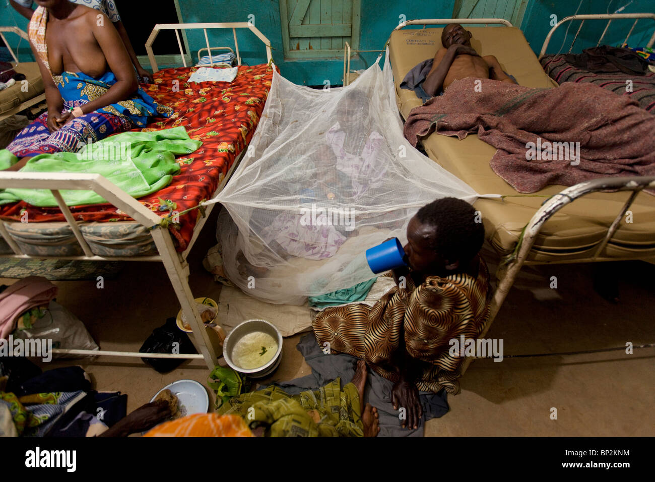 Pazienti poggiano sul pavimento di un affollato ospedale in Amuria, NE Uganda, Africa orientale. Foto Stock