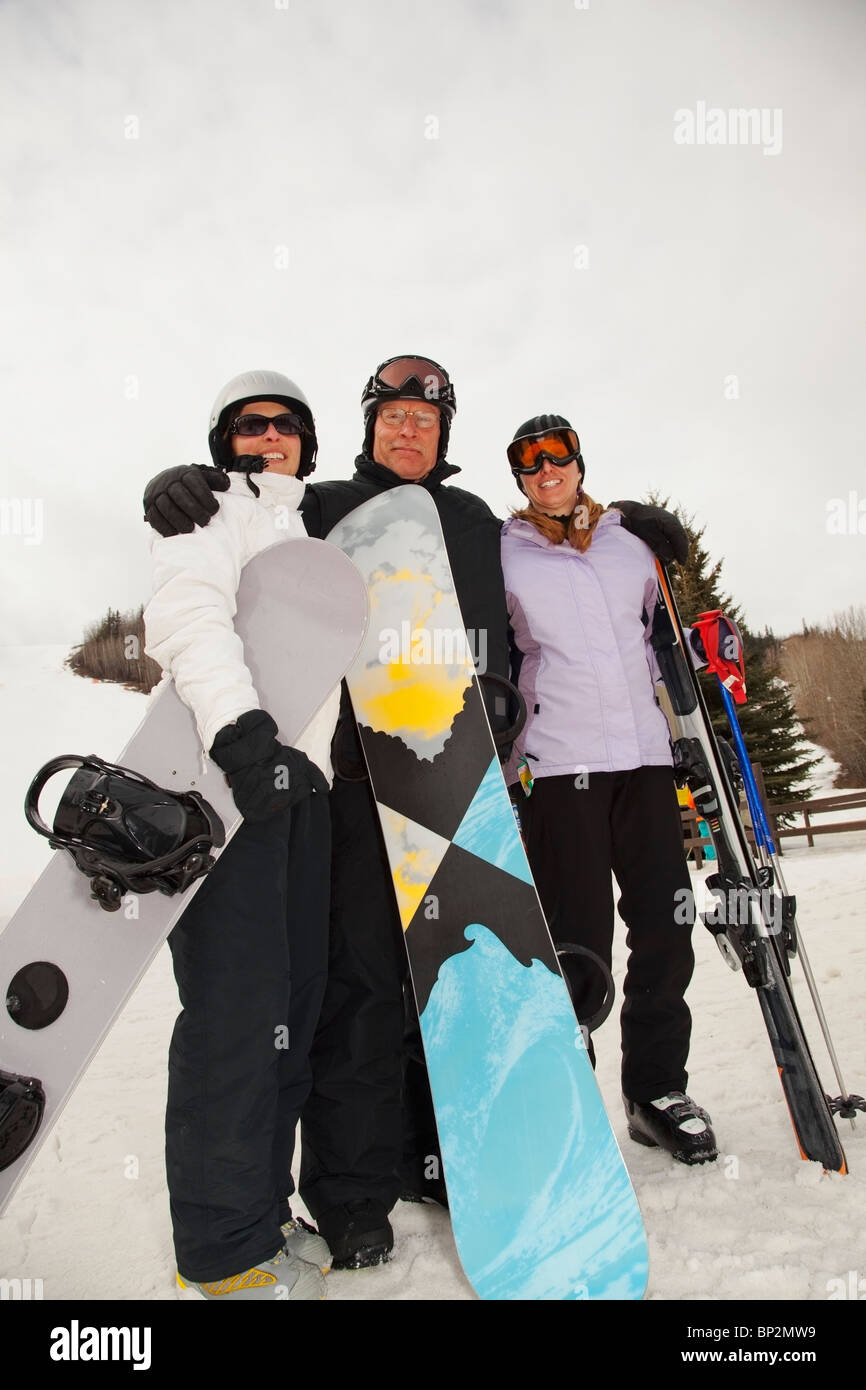 Cervi, Alberta, Canada; tre adulti in una ski area azienda snowboard e sci Foto Stock
