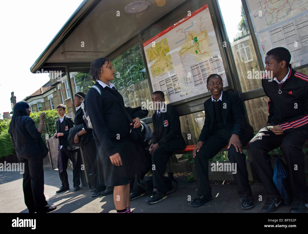 La scuola dei bambini in attesa di bus sulla strada di casa da scuola Foto Stock