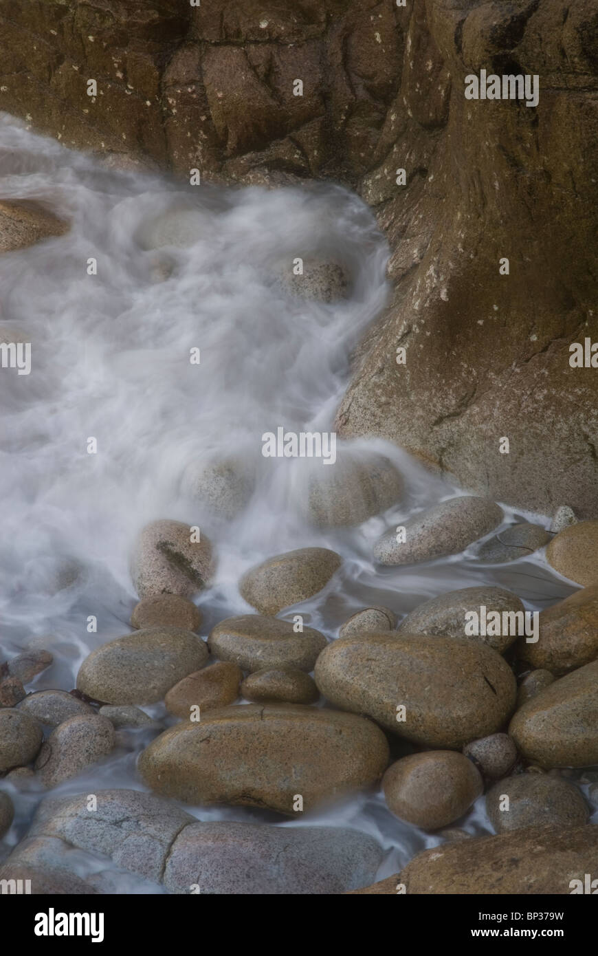 Onde di oltre le rocce a Porth Naven Foto Stock