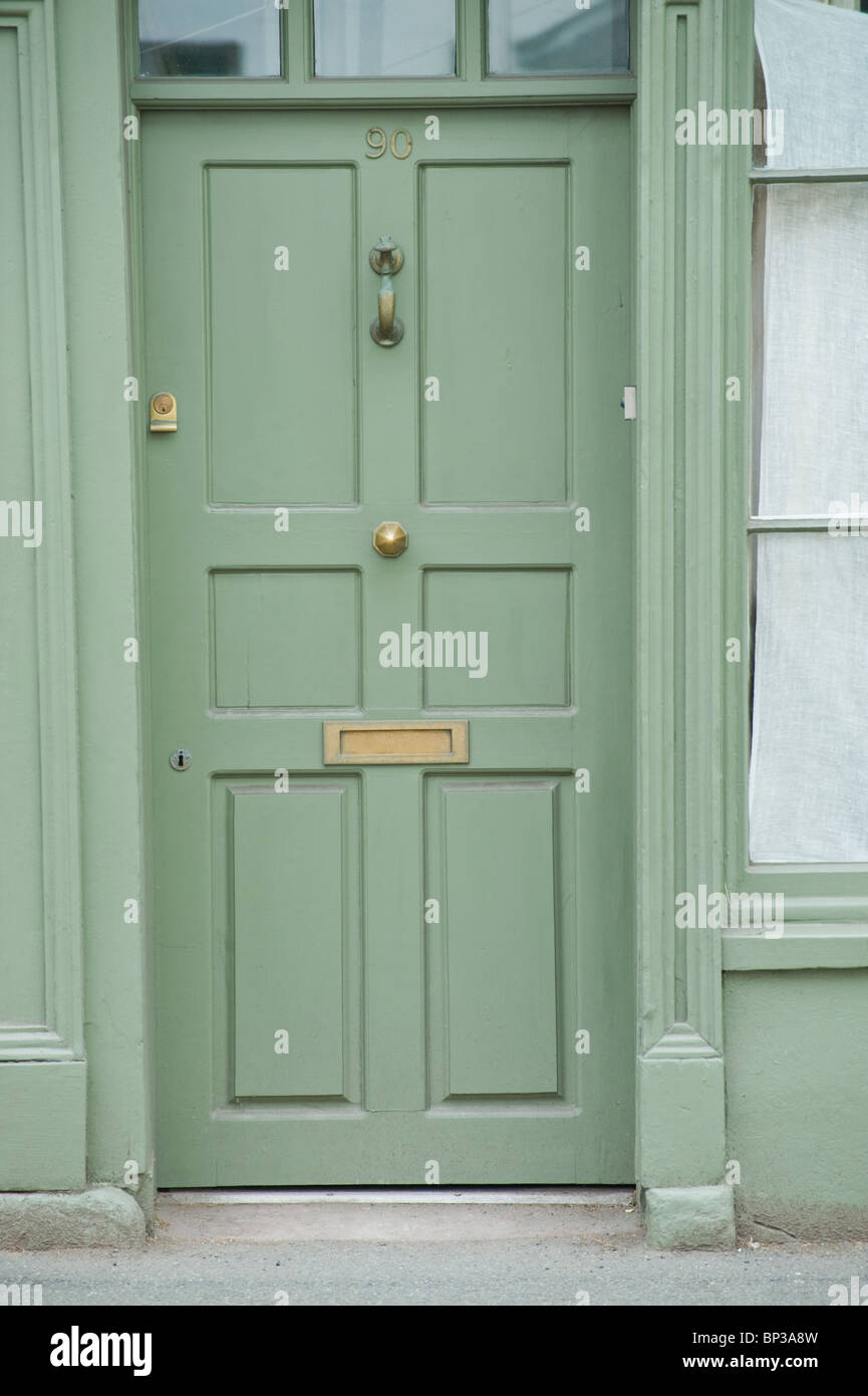 Dipinto di verde in pannelli di legno porta anteriore n. 90 con ottone respingente letterbox e la manopola di casa nel Regno Unito Foto Stock