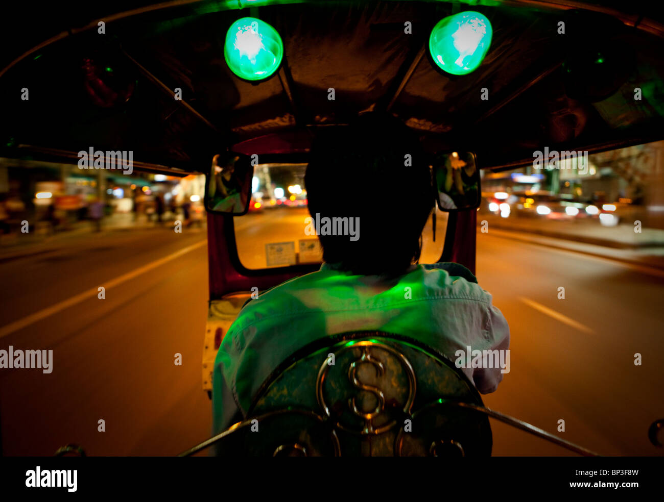 Un Tuk Tuk driver Zips il suo modo attraverso Bangkok Foto Stock