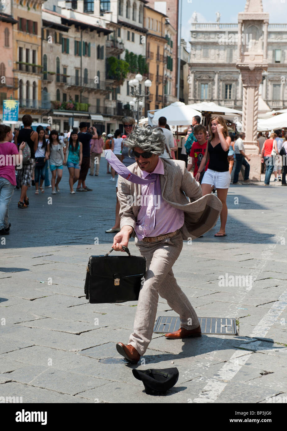 Street performer vestito come un imprenditore occupato si erge ancora in Piazza Erbe Verona Italia Foto Stock