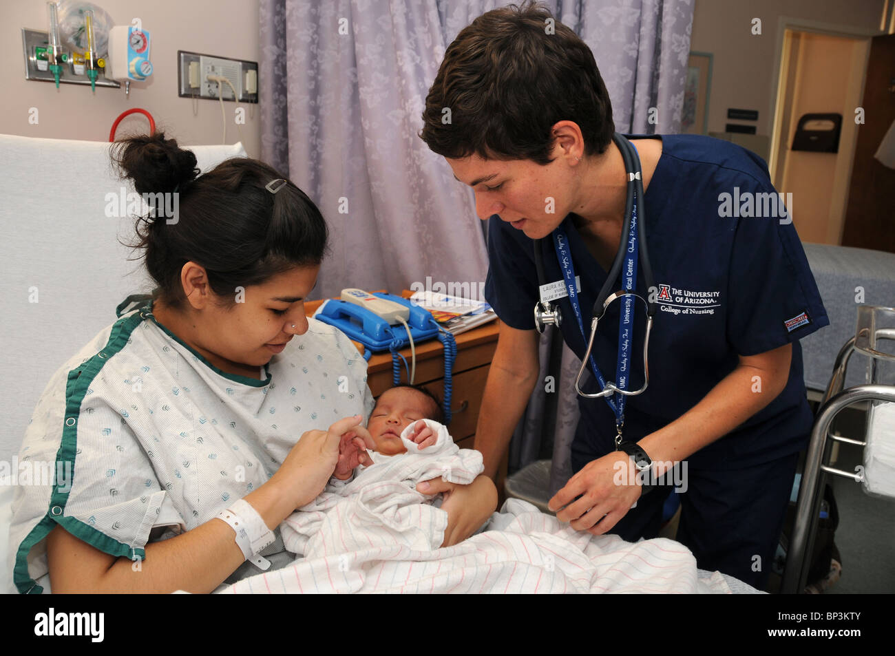 Una madre e il suo 2 giorno di età infantile con uno studente di infermieristica presso un ospedale. Foto Stock