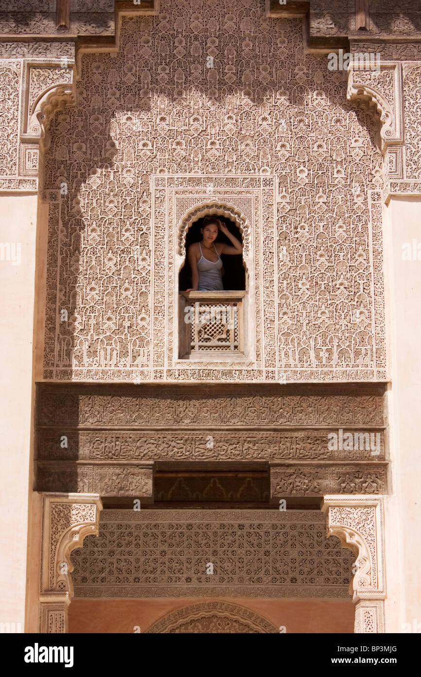 Donna che guarda fuori della finestra a Ben Youssef Medersa, Marrakech Foto Stock