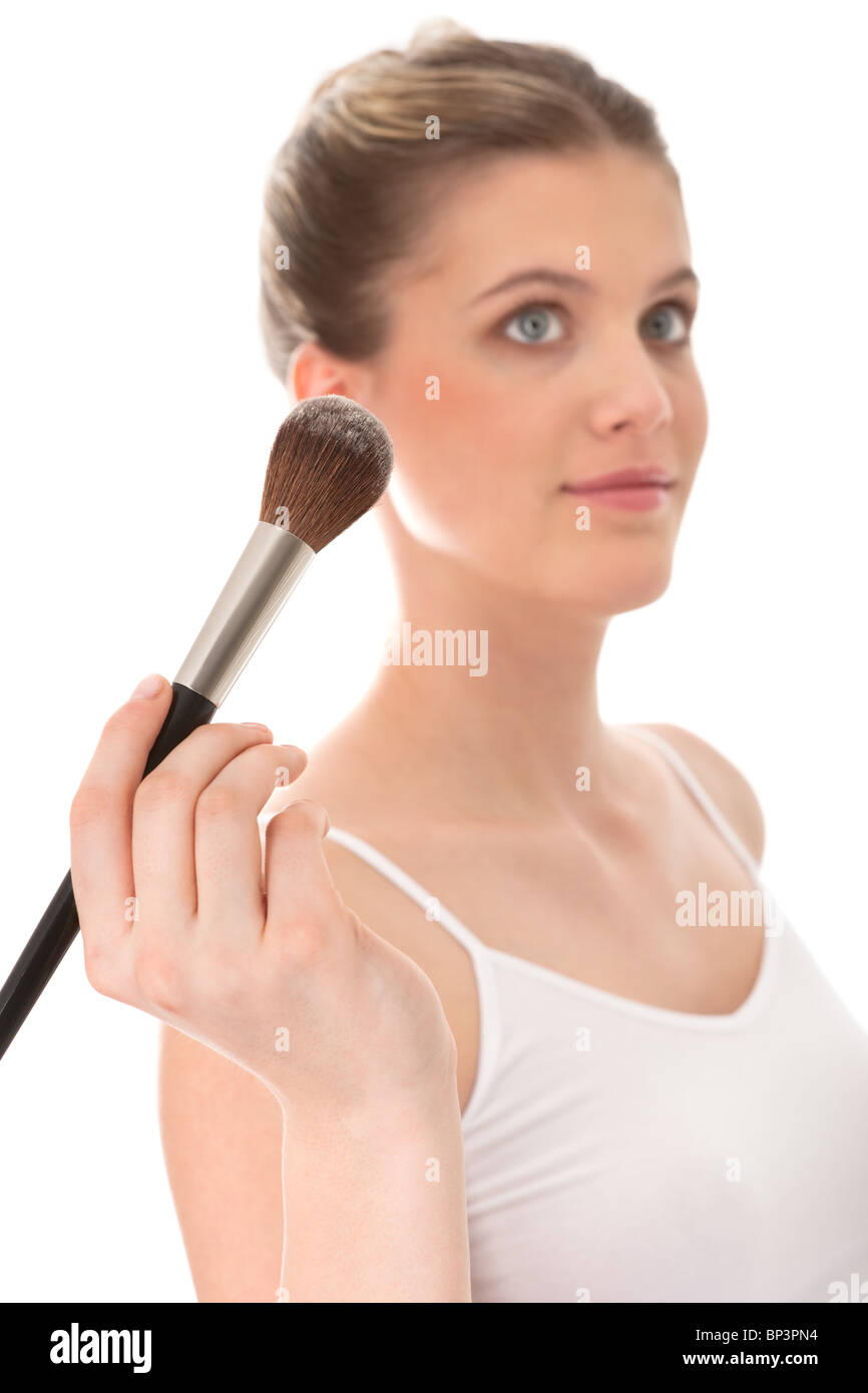 Giovane donna facendo il make-up, la messa a fuoco sulla spazzola Foto Stock