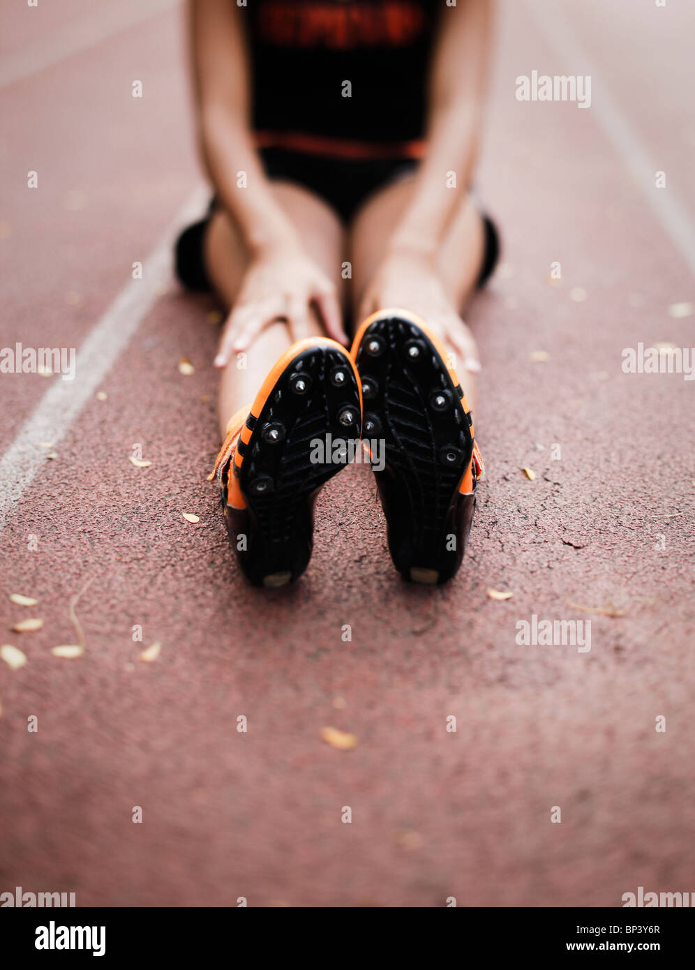 African American sprinter girl stretching gambe su di una traccia Foto Stock
