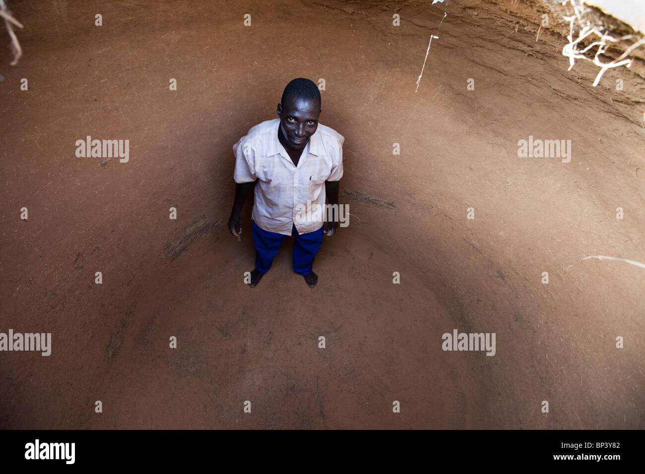 ZANTARAM VILLAGGIO, 5 km AD OVEST di GUIDAM IDER, NIGER, 27 LUGLIO 2010: Un giovane si trova nel suo deposito di grano - è completamente vuoto. In tempi normali ci sarebbe un stock dal raccolto dell'anno scorso per durare fino a questo raccolto di anno. Molti nel villaggio stanno mangiando le erbacce, conosciute localmente come Garsia, poichè non hanno nient'altro. Foto di Mike Goldwater / Christian Aid Foto Stock