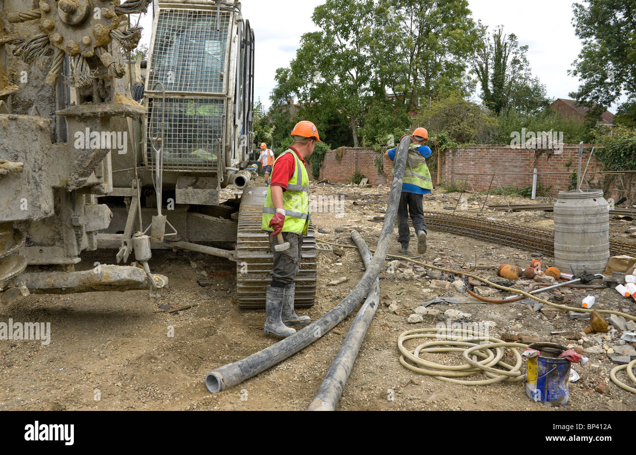 Workman trascinando una lunghezza del tubo in posizione, pronto per la connessione di due lunghezze insieme. Foto Stock