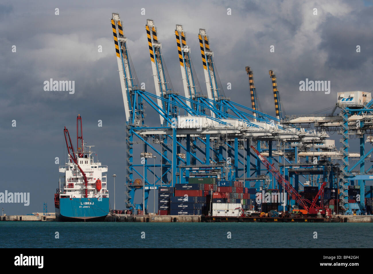 Gli scambi internazionali mediante il trasporto marittimo. Nave cargo presso il Malta Freeport contenitore porta. Spese di spedizione, lo sviluppo economico e la crescita del PIL. Foto Stock