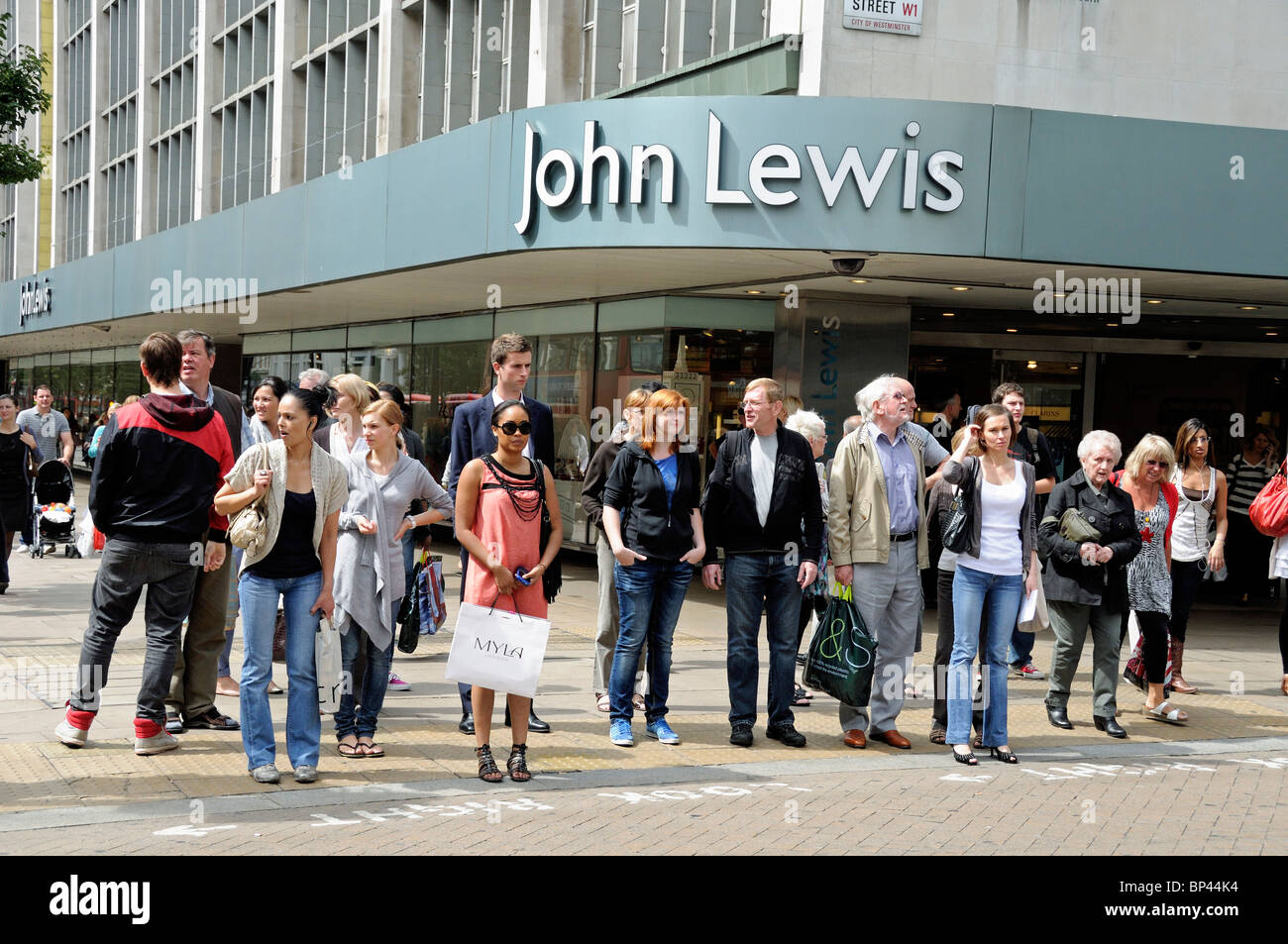 Pedoni che attraversano la strada di fronte a John Lewis, Oxford Street, Londra Inghilterra Gran Bretagna REGNO UNITO Foto Stock