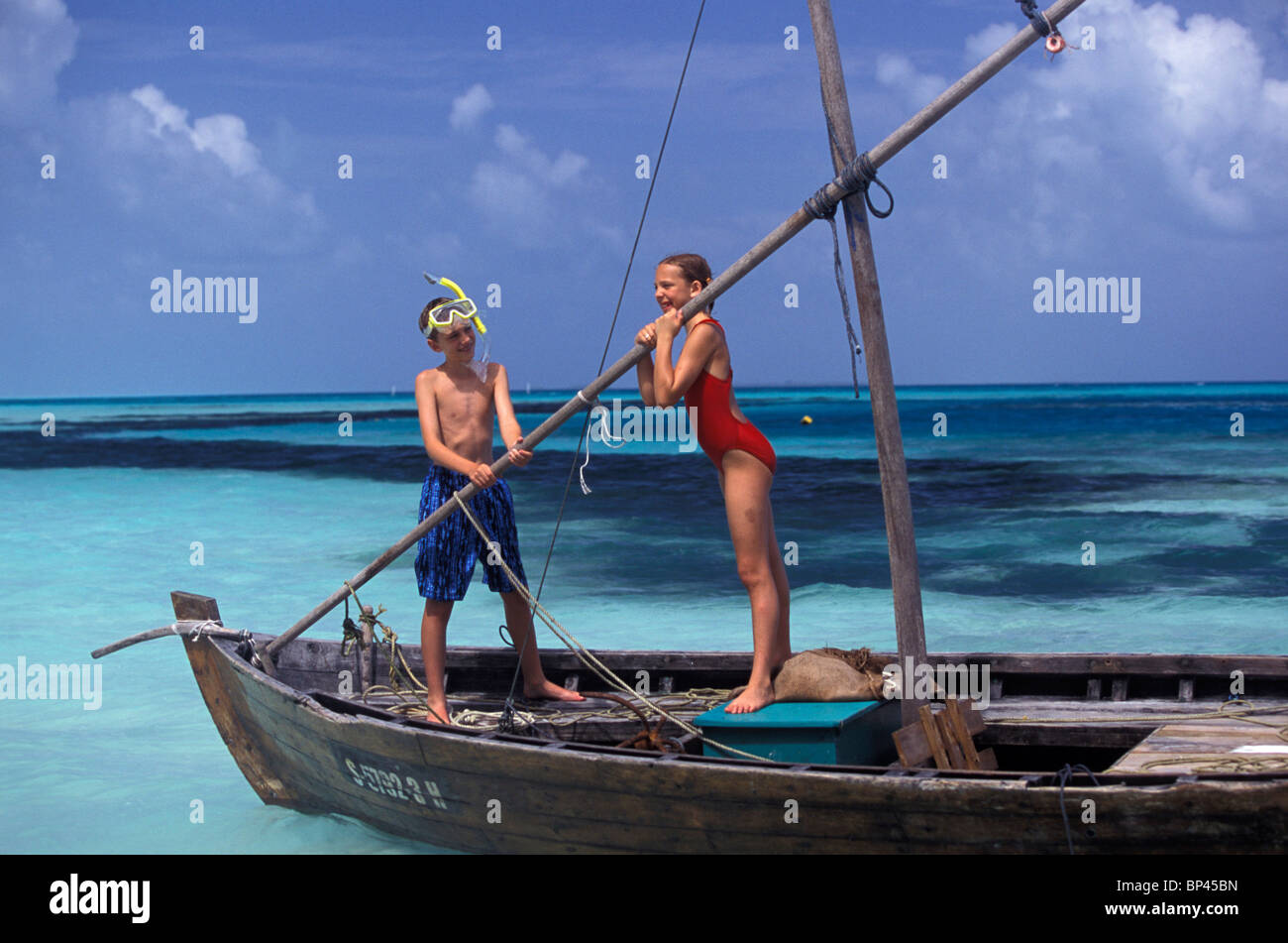 Maldive. Ragazzo e una ragazza (età 12) giocando sul dhoni tradizionale (barca) Foto Stock