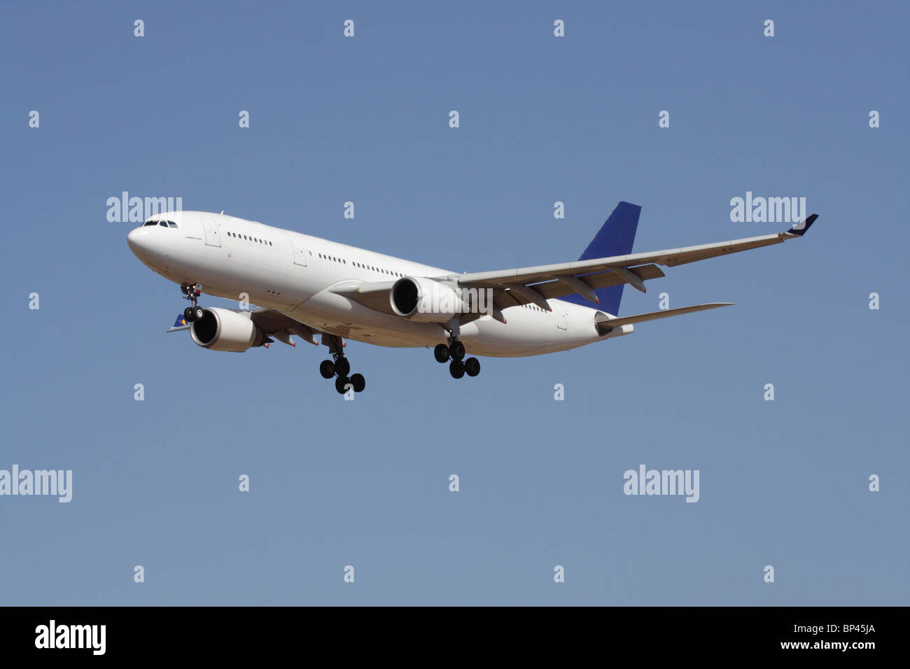 Viaggi aerei. Airbus A330 a lunga percorrenza con un aereo da passeggeri commerciale in volo contro un cielo blu. Nessun livrea e dettagli proprietari cancellati. Foto Stock