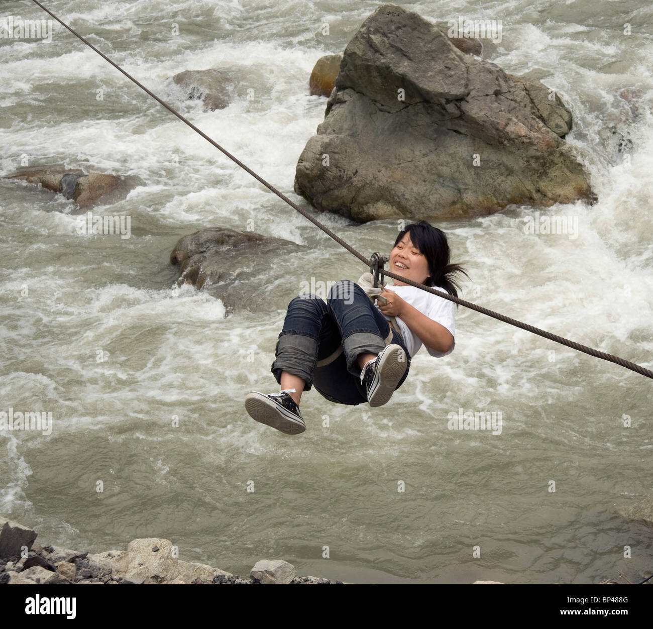 Attraversando il fiume Pitiao, Wolong su un filo zip Foto Stock