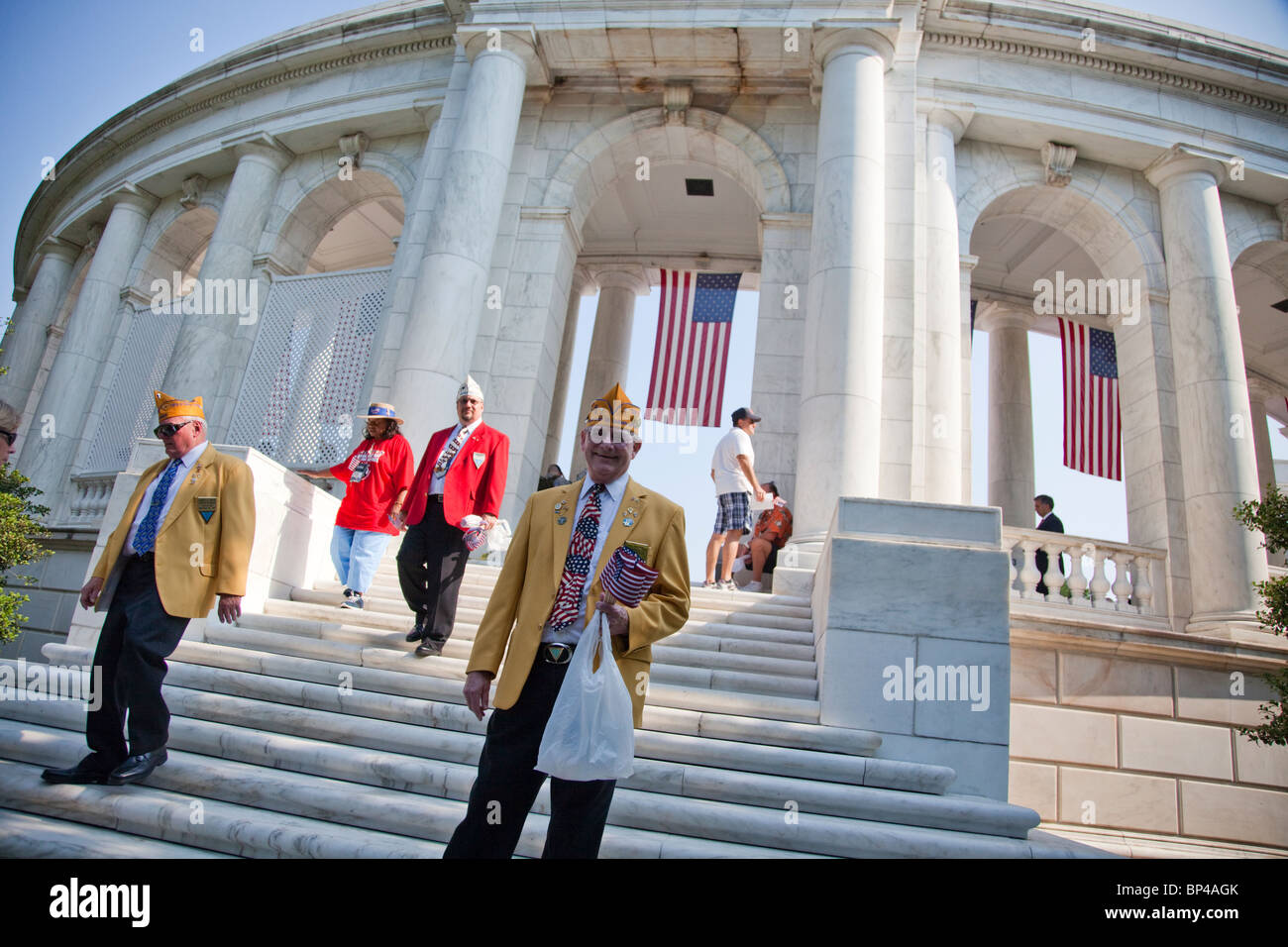 Veterani passano fuori bandierine americane di visitatori presso il Cimitero Nazionale di Arlington, Anfiteatro memoriale del Memorial Day. Foto Stock