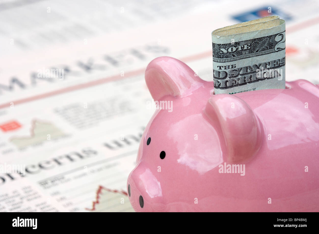 Rosa salvadanaio con 20 dollar nota seduto su una copia del Financial Times money markets sezione nel Regno Unito Foto Stock