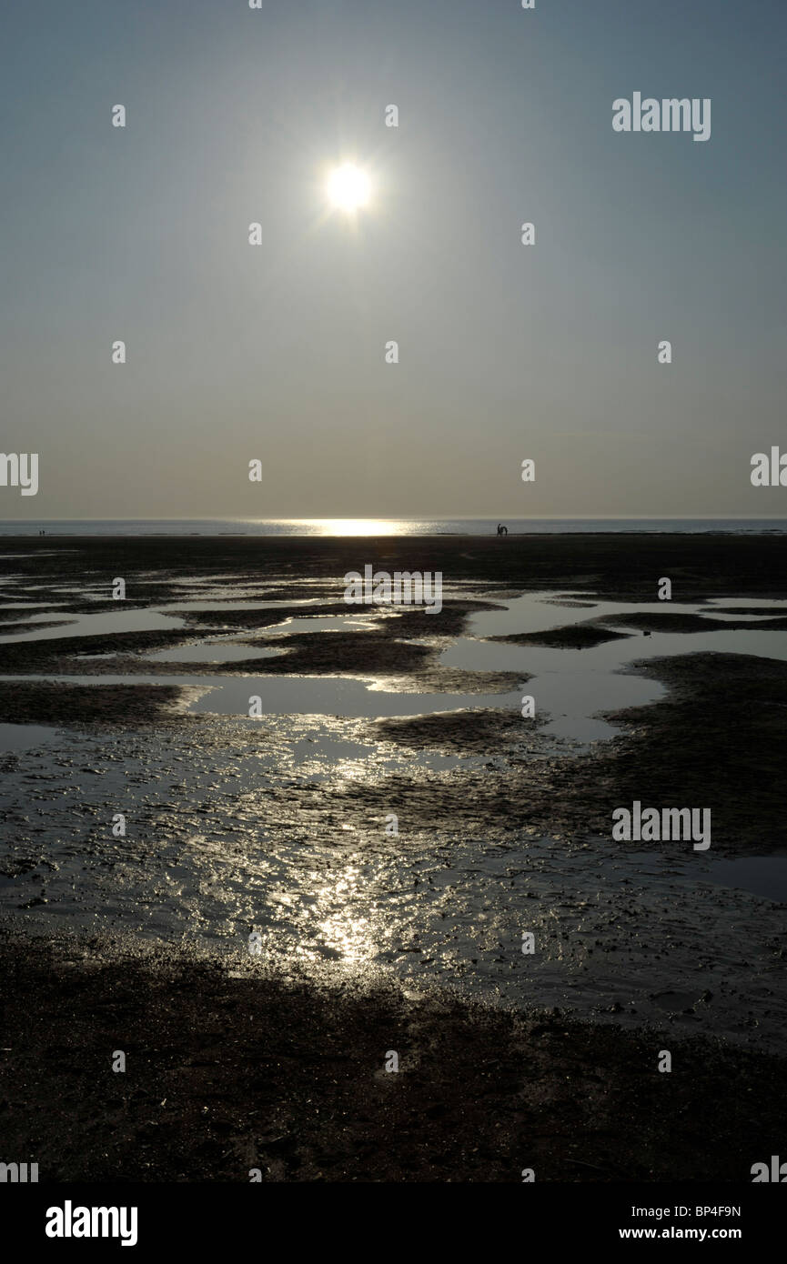 Tramonto sulla spiaggia a Hunstanton con figure distanti, Norfolk. Foto Stock