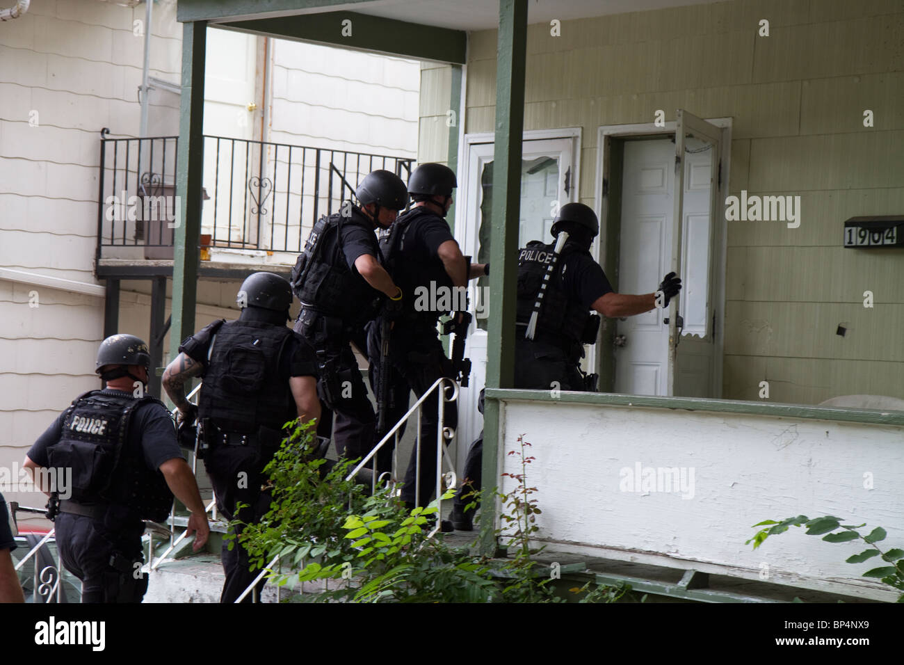 La polizia Tactical team da strada Unità narcotici approccio residence a servire un farmaco relative ad alto rischio di un mandato di perquisizione. KC MO/Pd. Foto Stock