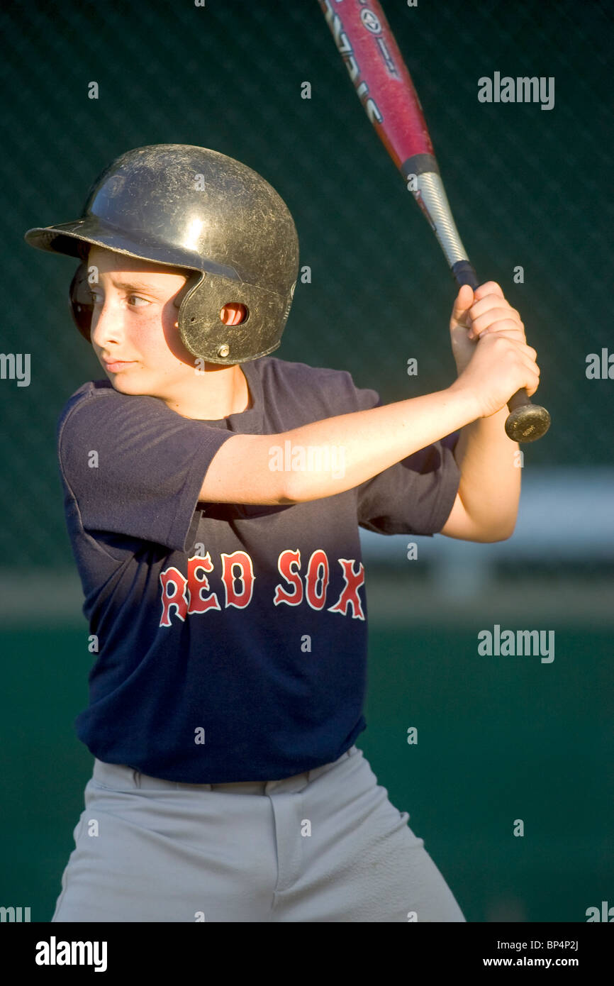 10 anno vecchio ragazzo batting durante una partita di baseball. Foto Stock