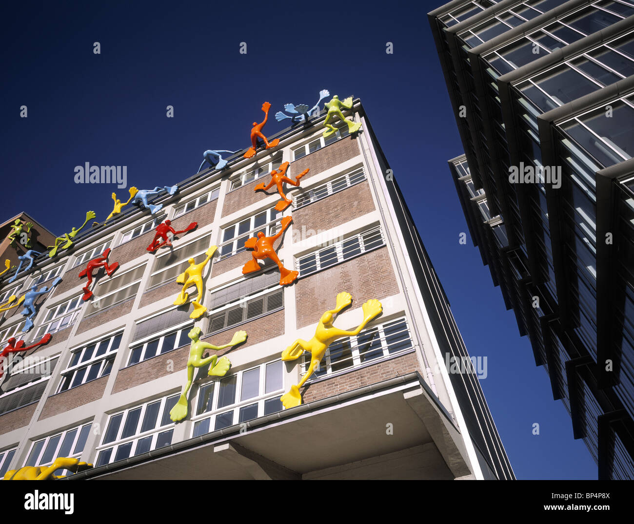 Magazzino rinnovato con divertenti figure di arrampicata al Medienhafen di Düsseldorf, Germania. Foto Stock