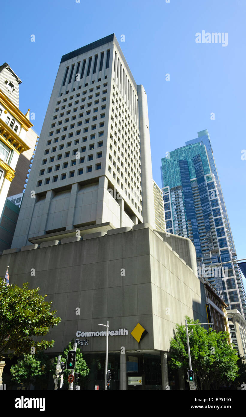 Un alto brutalist skscraper contenente sedi bancarie con altri edifici alti dietro Foto Stock