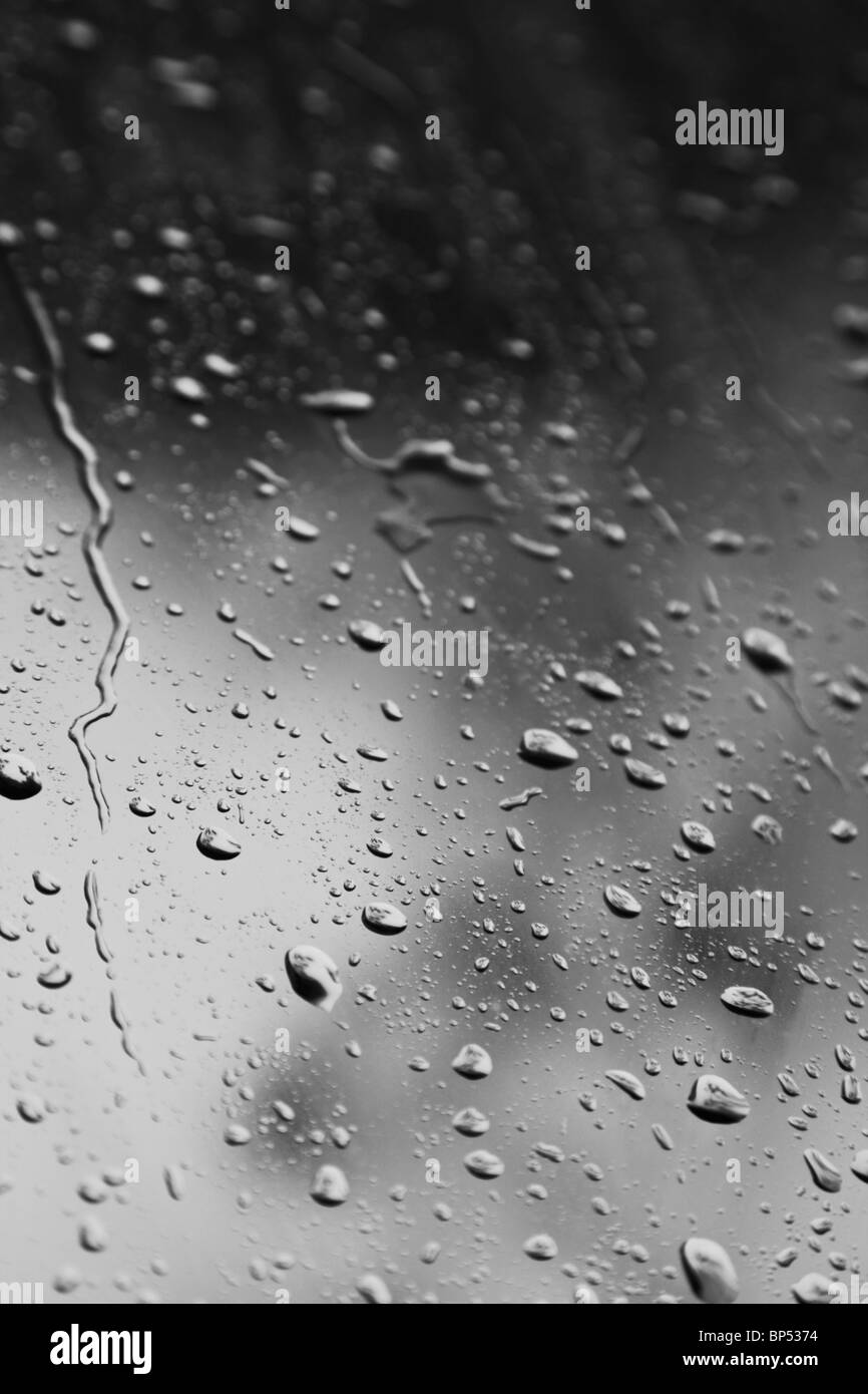 La pioggia lo sgocciolamento e dribbling verso il basso una finestra Foto Stock