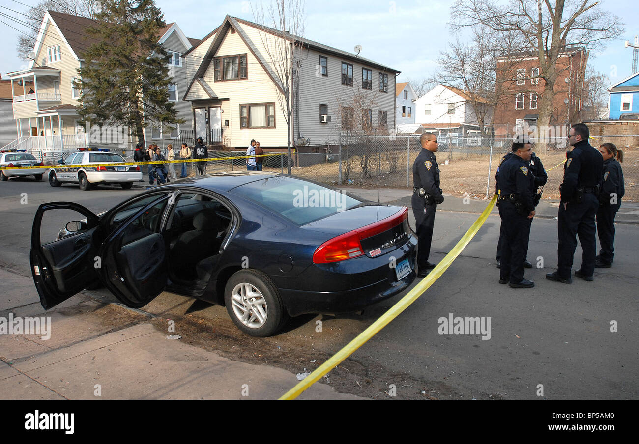 New Haven, CT USA--New Haven poliziotti sostare nelle vicinanze di un'auto eventualmente utilizzati in un doppio tiro. Essi sono mostrati in 44 Elliot Street dove i sospetti salvò della vettura. Foto Stock
